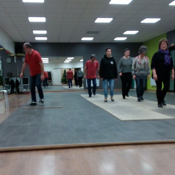 Un cours de claquettes dans la salle de danse, devant les miroirs.