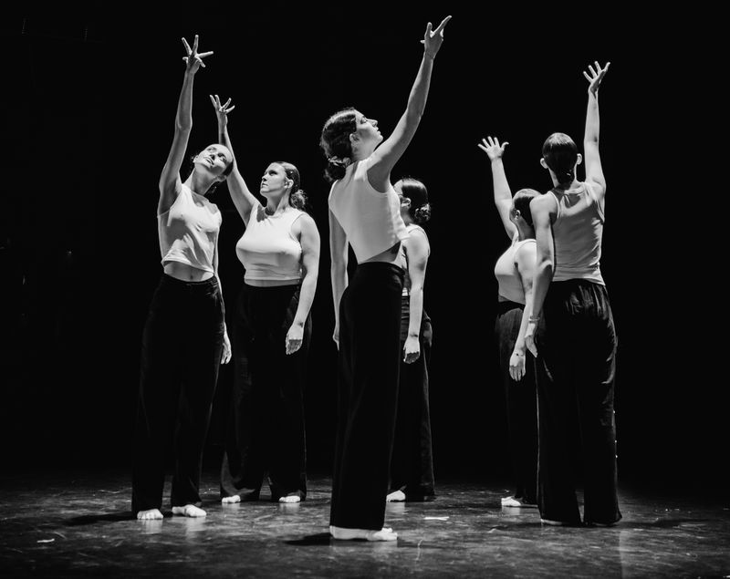 Six danseuses de modern’jazz lèvent un bras vers la lumière. Photo en noir et blanc.